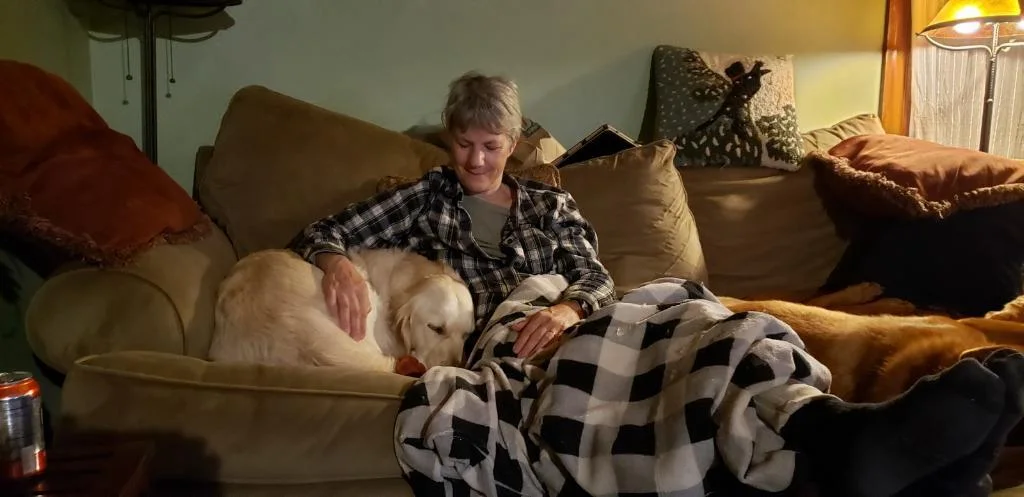 Leslie relaxing indoors with dogs in her care
